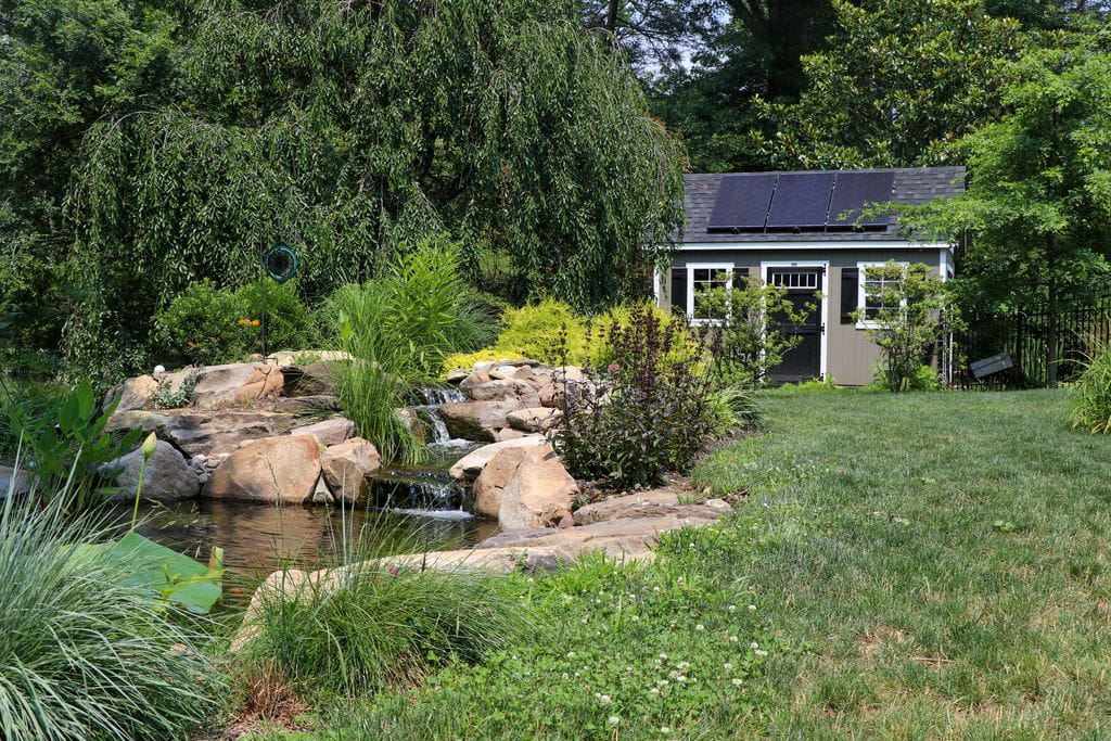 Backyard pondless waterfall with boulders and solar shed by AquaReale in Philadelphia PA